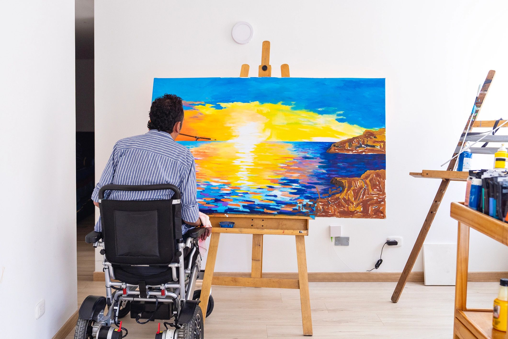 Artist painting a seascape in a studio